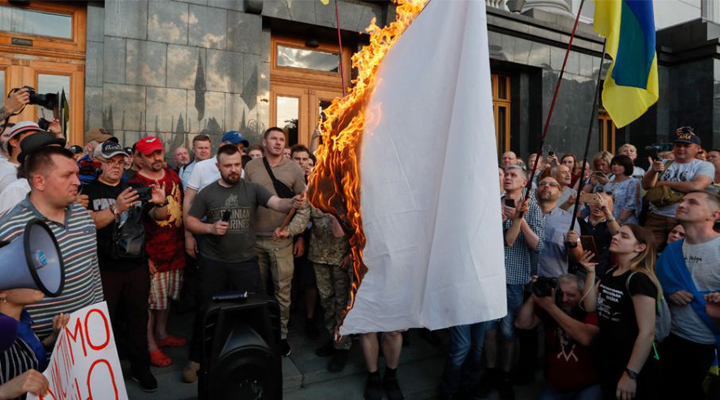 демонстранты сжигают белый флаг