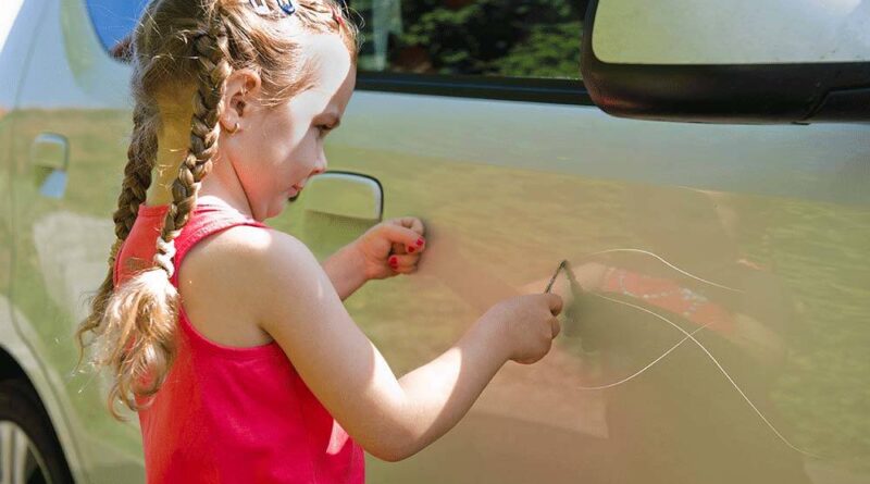 дівчинка малювала камінням на автомобілях